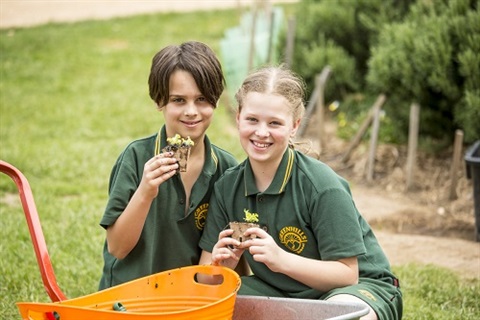 two kids potting plants